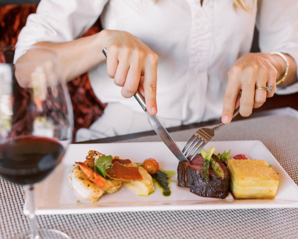 Guest cutting into steak