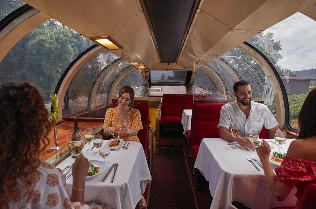 Two couples sat side by side enjoy their dinner and wine