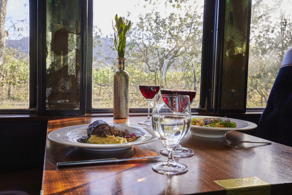 Steak dinners served with red wine onboard the Wine Train