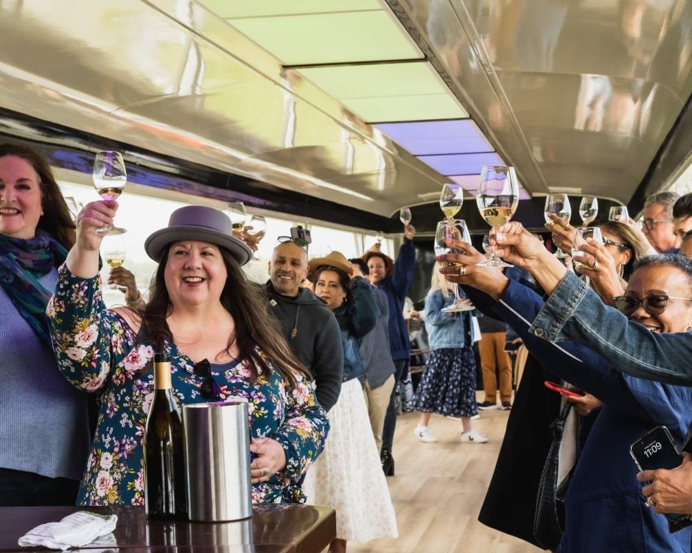 A group of guests raise their wine glasses in toast