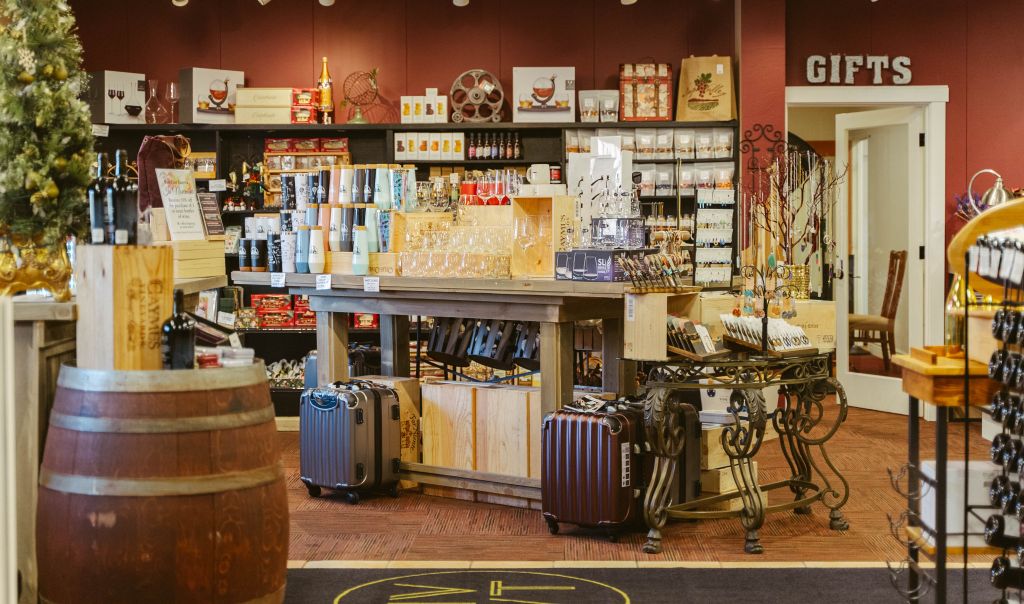 Retail Wine Store with suitcases, wine barrels and merchandise on display