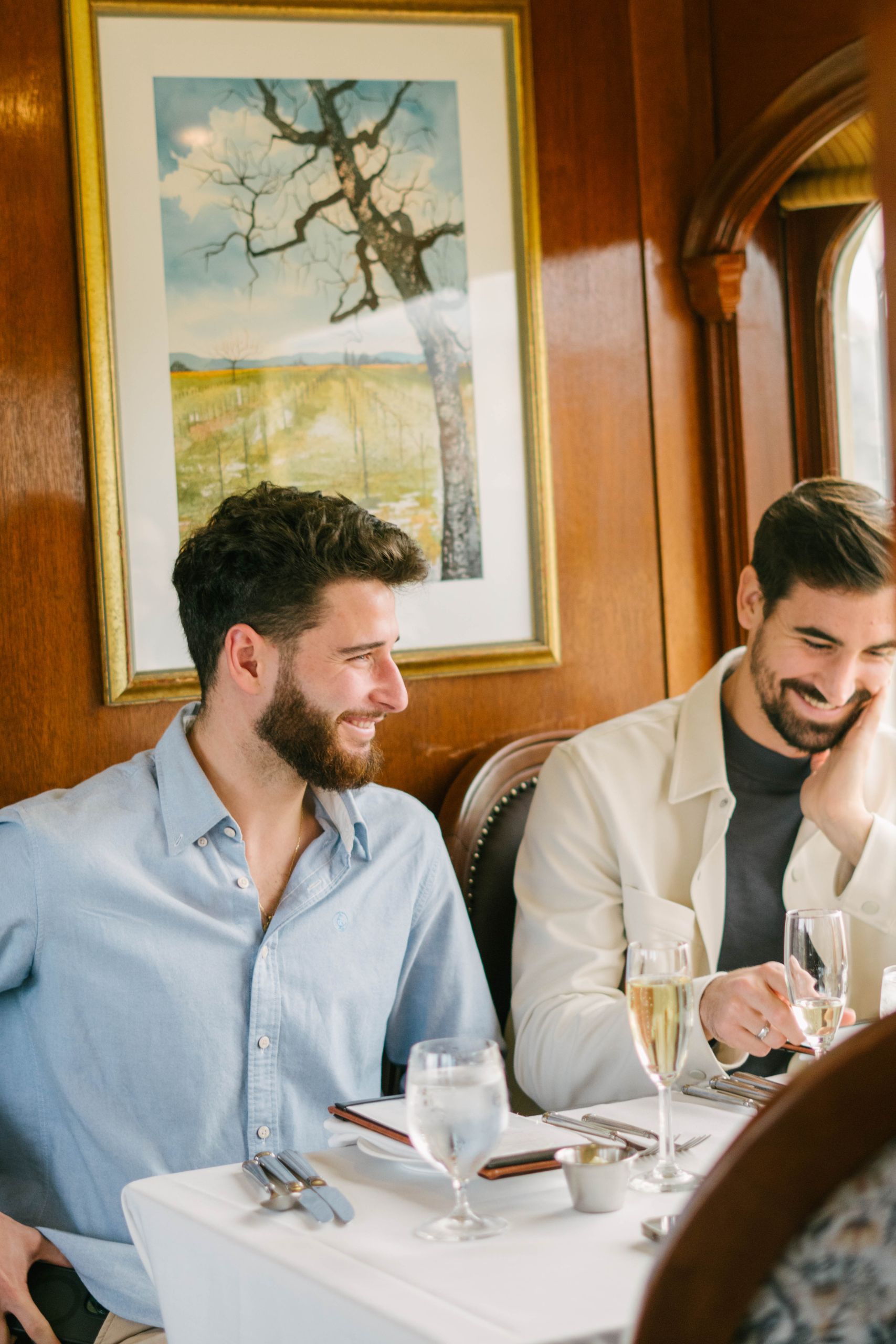 Two adults sat at a dining table onboard the Wine Train