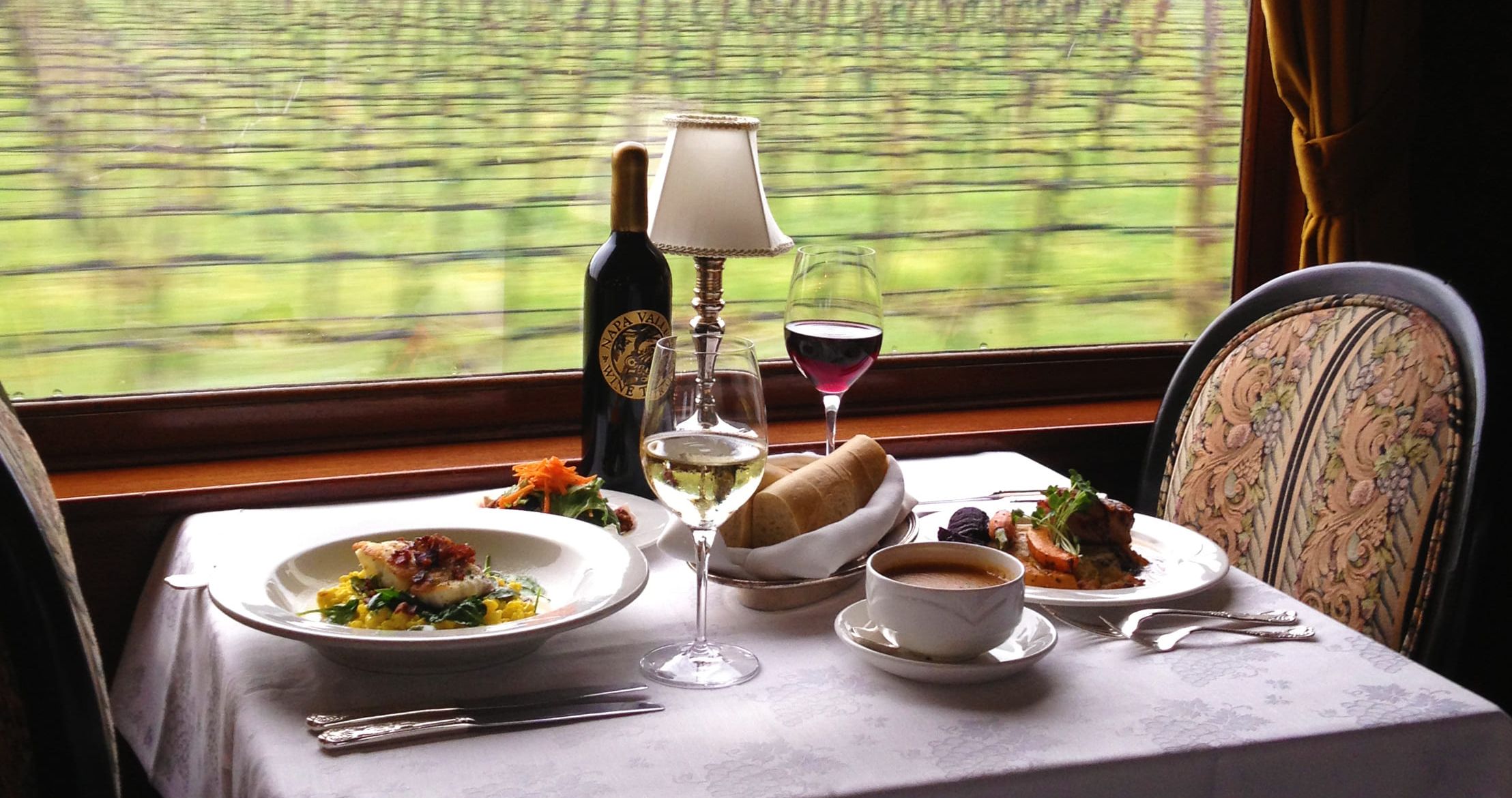Dinner is served! Full plates and glasses of wine or coffee await guests as the Wine Train travels through vineyards