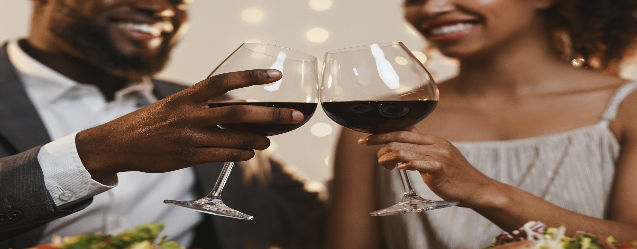 Couple clinks their glasses of red wine