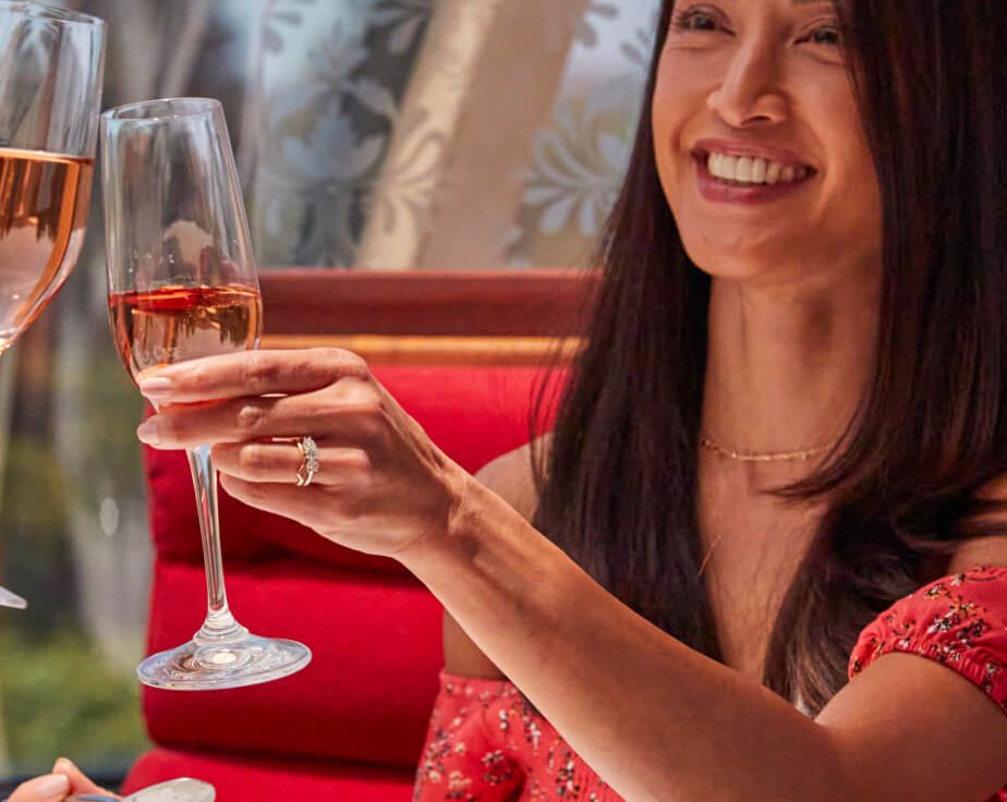 Woman clinks her wine glass in toast