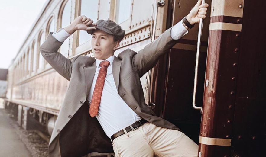 Man hangs from train while tipping his hat
