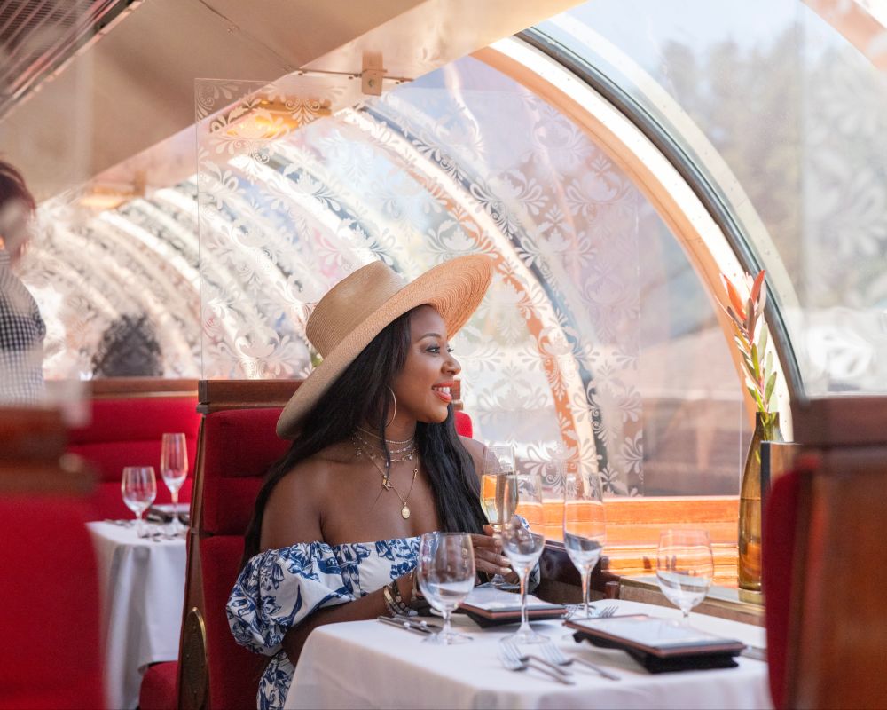 A woman holding a wine glass looks out her window