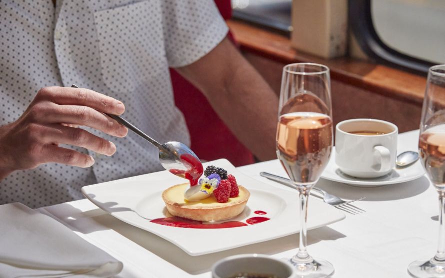 Guest gingerly breaks their berry tart dessert with a spoon