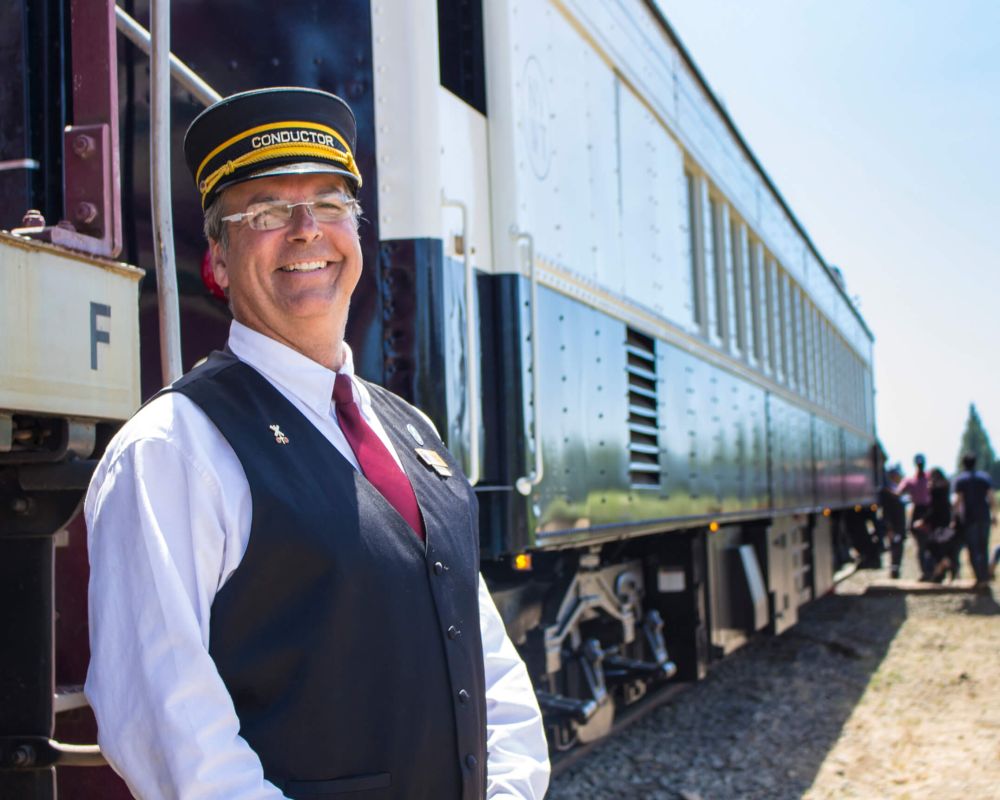 The Conductor poses in front of the Wine Train