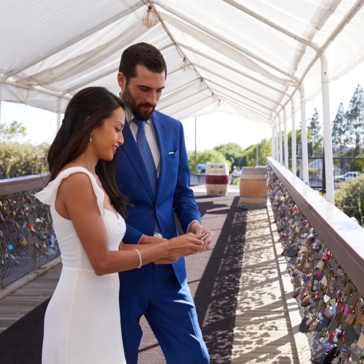 Bride and groom decide where to play their lock on the chain link fence