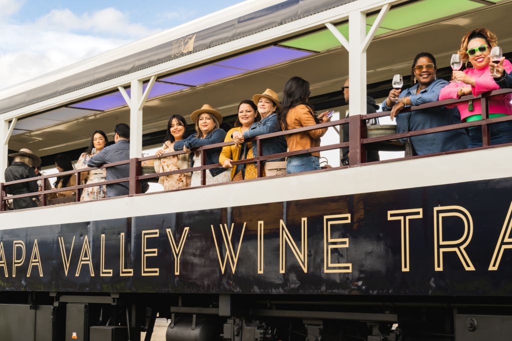 Passengers look out from an open air car aboard the Wine Train