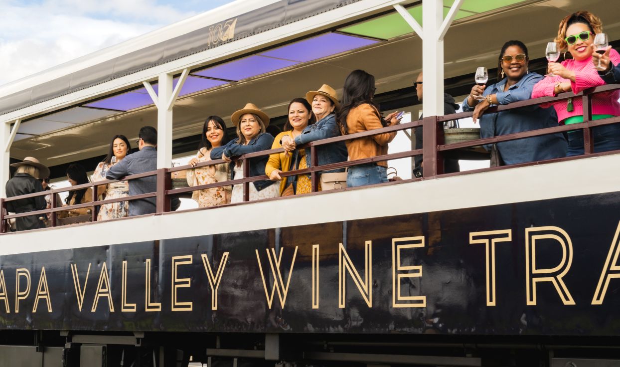 Passengers look out from an open air car aboard the Wine Train