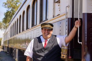 Conductor poses alongside train