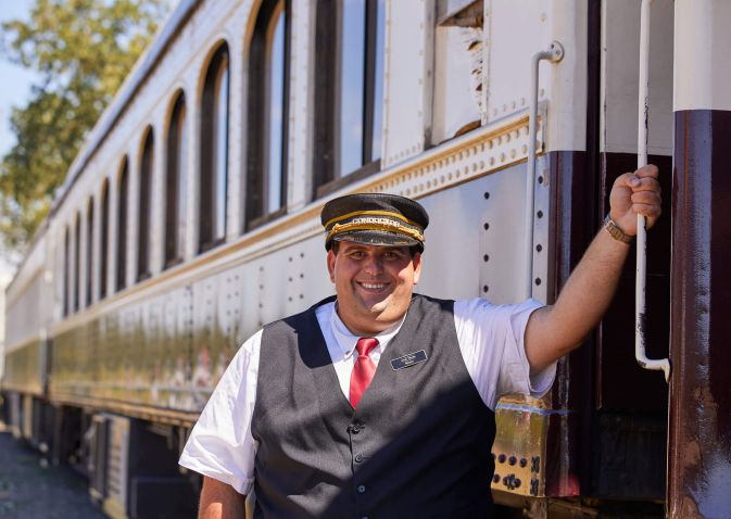 Conductor poses alongside train