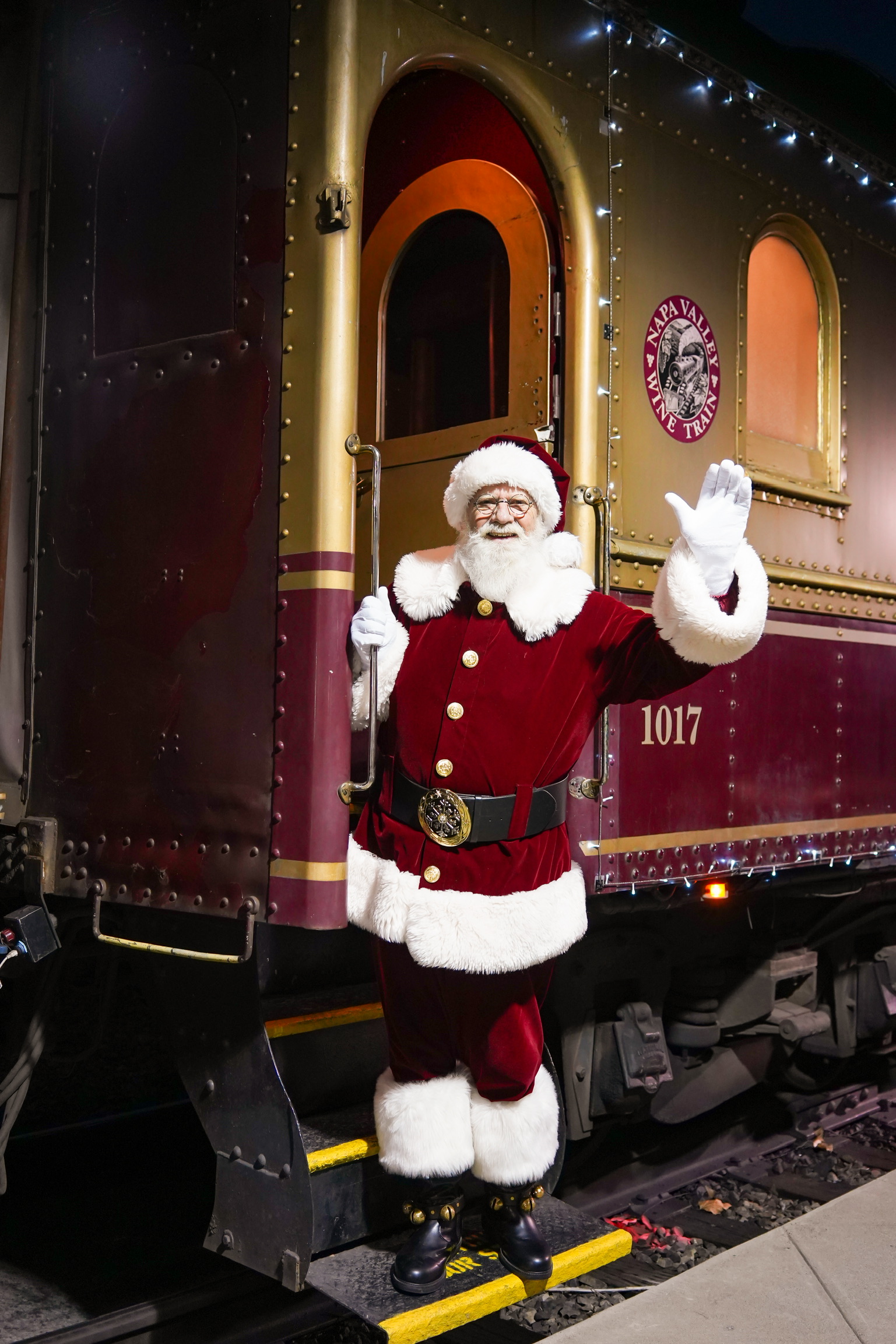 Santa Klaus waving as he stands on the Wine Train