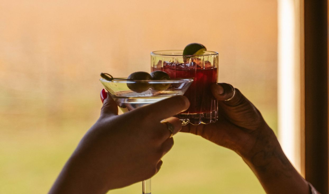 Two cocktails being clinked in toast