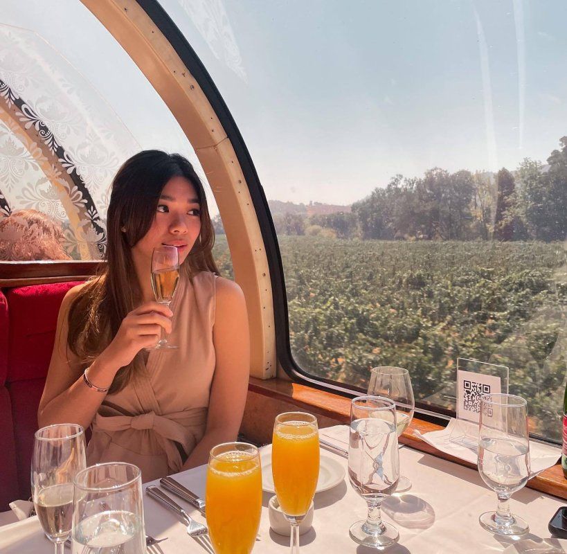 Woman sipping wine looks out at vineyards