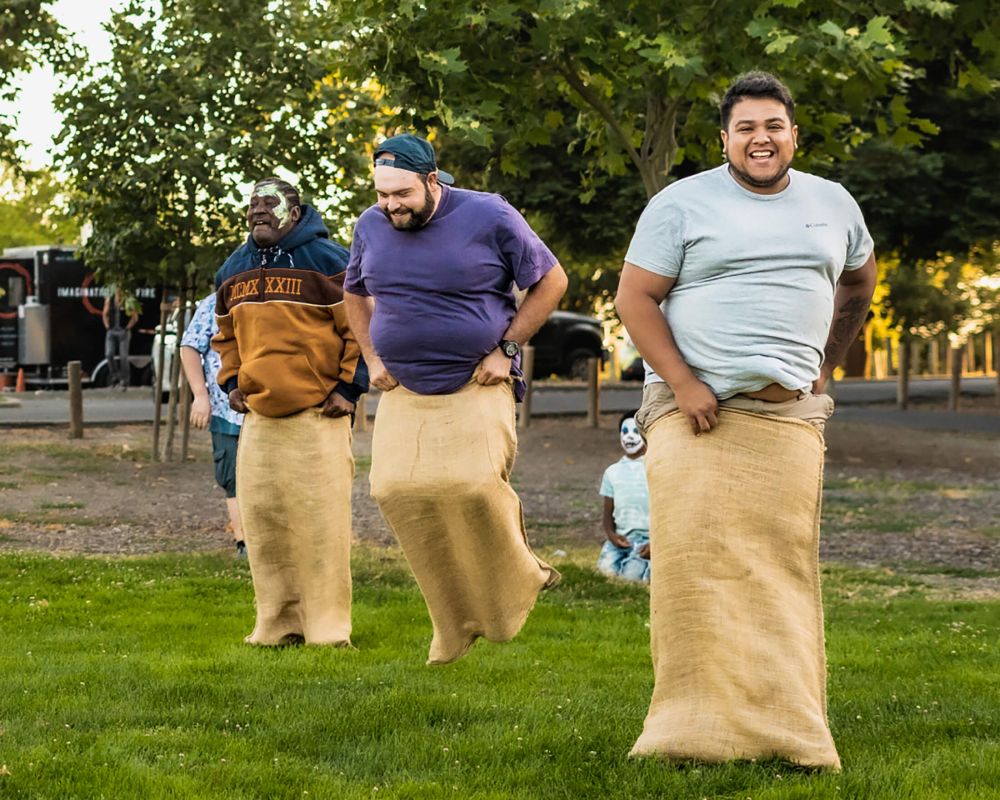 Guests laughing during a potato sack race