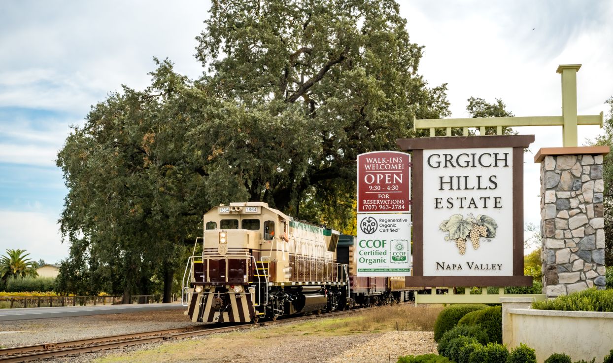 Wine Train front exterior stopped next to the Grich Hills estates welcome sign