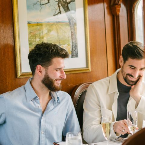 Two adults sat at a dining table onboard the Wine Train